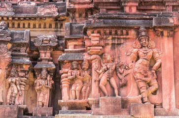 Hampi, Karnataka, India - November 5, 2013: Vijaya Vitthala Temple. Closeup of 4 sets of statues on red stone Gopuram.