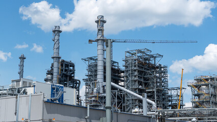 Construction with cranes of a large blue chemical plant at an oil refinery, petrochemical plant. Industrial concept.