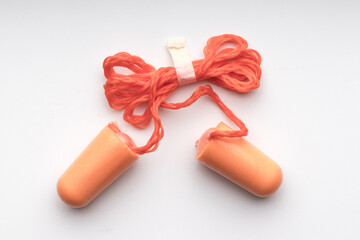 Pair of earplugs with orange colored rope, top view
