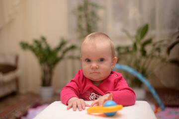 A small child plays with toys at home at the children's table