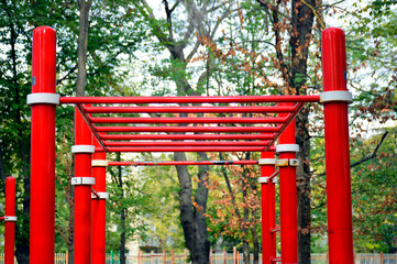 Fototapeta na wymiar red metal handle for gymnastics on the playground in the park