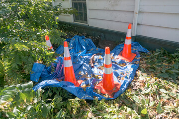 Construction site covered with blue tarp and orange and white striped warning cones. St Paul Minnesota MN USA