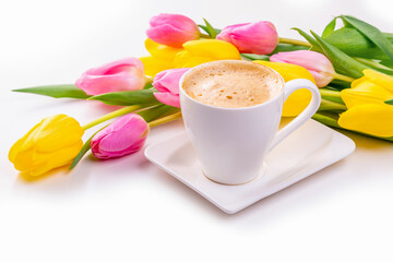 white cup with coffee and tulips on white background