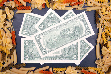 frame from italian pasta with dollars on a dark background. flour products and food in cooking