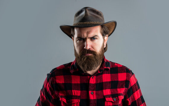 cowboy guy with long beard. brutal mature hipster wear checkered shirt and hat. wild west