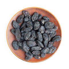 Dark blue raisins on a plate isolated on white background, top view
