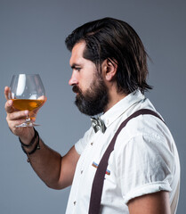 brutal bearded male with stylish look drinking brandy, restaurat