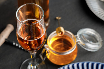 Glass of wine and corkscrew on black table