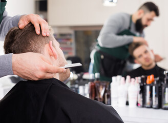 Fototapeta premium Hairdresser making haircut to client at hair salon