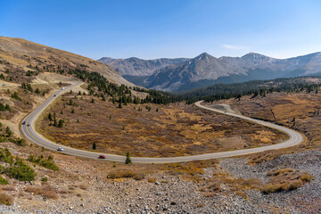 Autumn Mountain Road - A panoramic overview of a winding mountain road at east of the summit (12,126 ft) of Cottonwood Pass on a sunny Autumn afternoon. Buena Vista - Crested Butte, Colorado, USA.
