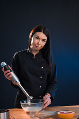 Lovely woman mixing flour with eggs while using whisk. She is cooking bakery.
