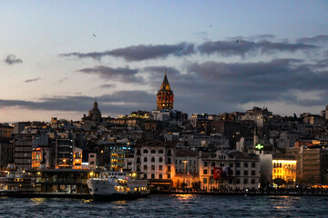 Fototapeta na wymiar Motion blur view of İstanbul cityscape at dusk. Amazing capture of Galata Tower and old buildings around it with lights in the evening.