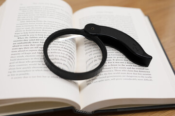 Open book with magnifying glass