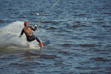 Young man riding wakeboard on a summer lake