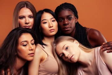 young pretty asian, caucasian, afro woman posing cheerful together on brown background, lifestyle diverse nationality people concept