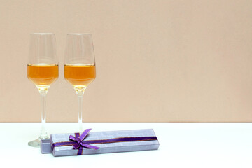 Two champagne glasses and gift box on Valentines day, white background with copy space. love concept