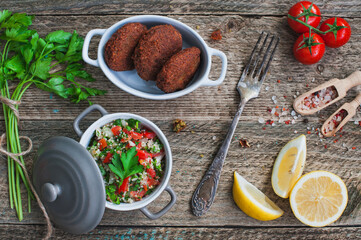 Table served with middle eastern traditional dishes. Bowl with falafel, vegetarian pita,  tabbouleh bulgur salad. Top view. Dinner party
