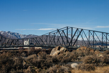 A large metal bridge over a river in a small American town in Washington state. Autumn sunny day with a bright blue sky. 02-08-2020, Washington, USA