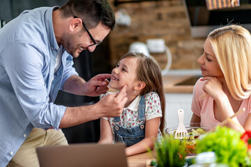 Family using laptop in kitchen