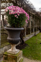 concrete vase on a stand with flowers in the garden