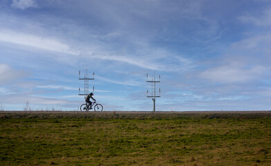 cyclist with airfield transmitters and whispy blue sky background