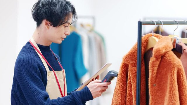 アパレルの在庫管理をする男性　商品管理　ハンディスキャナー　RFID