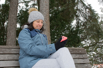 latin women using her phone in botanical garden montreal in the middle of the canadian winter