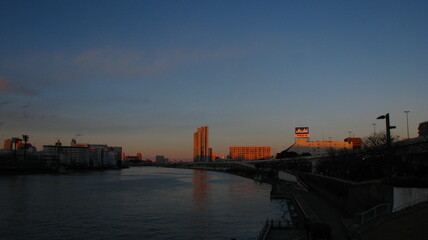 Fototapeta na wymiar 隅田川の夕景　夕焼けに染まるビル街