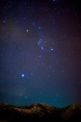 雪山と、冬の夜空に輝く星座オリオン座