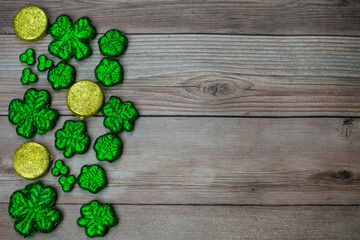 Glitter Covered Four Leaf Clovers Filling Half the Frame on a Wood Background