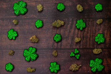 Cannabis Nugs and Glitter Covered Four Leaf Clovers on a Wood Background