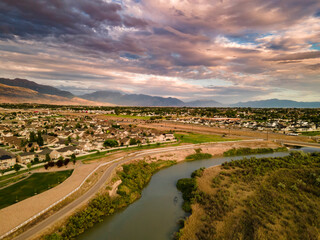 Fototapeta na wymiar Colorful sunset clouds over an urban area and river - aerial view