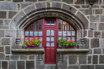 Fototapeta na wymiar cute door and windows of a medieval townhouse in the small town of Besse en Chandesse in Auvergne, France