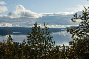 Fototapeta na wymiar Beautiful landscape with a large lake, blue mountains surrounding the lake, blue clear sky and sun