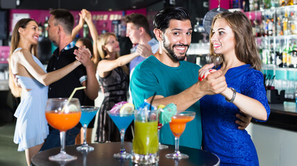 Young students dancing on party with the cocktails at the club