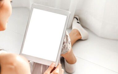 Smiling happy asian woman relaxing using tablet computer working with white mockup blank screens at...