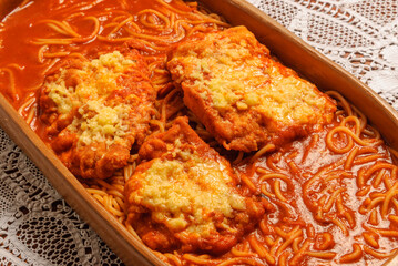 Parmigiana steak with tomato sauce and pasta.
