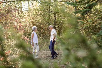 Obraz premium Senior couple in love and very happy enjoying a walk in the field at sunset