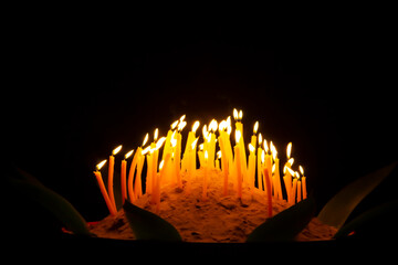 hand holding a burning candles in darkness with noise and grain effect bokeh.