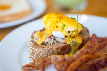 egg benedict with crispy bacon for breakfast