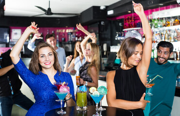 Young cheerful people celebrating birthday in the bar at evening