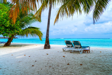 Obraz na płótnie Canvas Lounge chairs on a beautiful tropical beach at Maldives