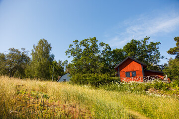 Classic Red summer garden cottage in Sweden. Traditional Sweden wooden old house in sunset light. Life on the one of Sweden islands