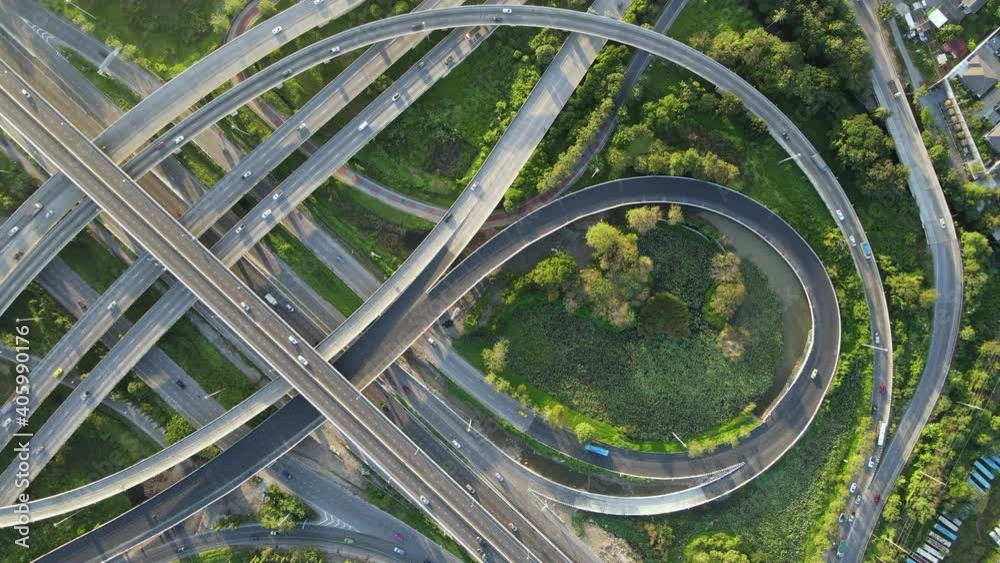 Poster 4K. Aerial view of road interchange or highway intersection with busy urban traffic speeding on the road. Junction network of transportation taken by drone. - Posters