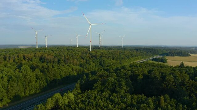 Wind Turbines in Germany on a sunny day in summer in Bavaria beside an Autobahn.