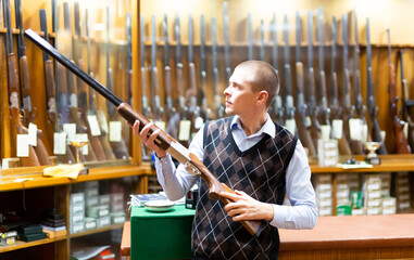 Fototapeta na wymiar Seller demonstrates a combat winchester in the gun store