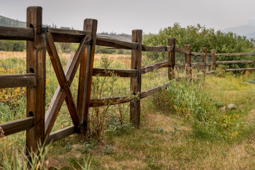 Fototapeta na wymiar Old Fence on a Farm in Colorado, USA overlooking green pasture and trees