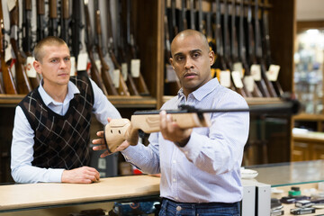 Seller demonstrates a combat winchester in the gun store