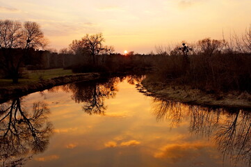 sunset. sunset over the river. atmospheric golden sunset over the river with reflection in water in the spring evening
