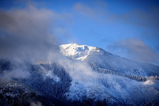 Snowy Mountain Peak Through Clouds Blue Sky